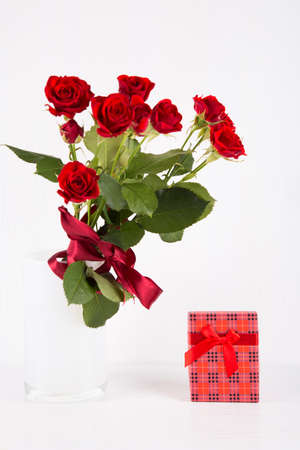 Bouquet of red roses with red gift box on white background.の写真素材