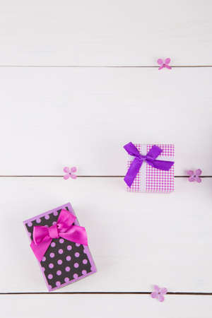 Two purple gift boxes surrounded by lilac flowers on white background.の写真素材