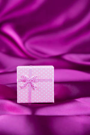 Gift box on curvy satin fabric background.の写真素材