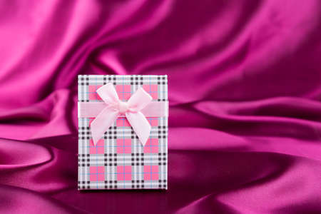 Gift box on curvy satin fabric background.の写真素材