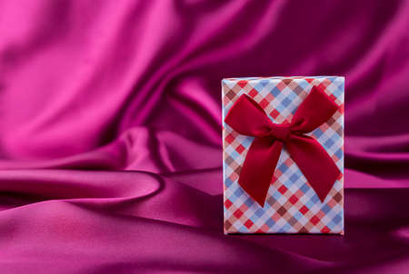 Gift box on curvy satin fabric background.の写真素材