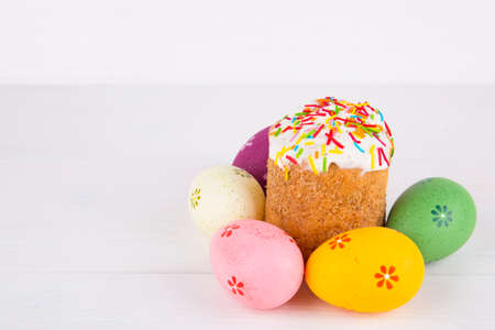Easter cake with colorful eggs on white wooden background.の写真素材