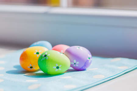 Colorful easter eggs on blue fabric near window.の写真素材