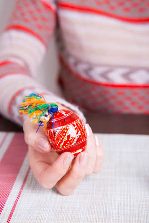 Colored easter egg with traditional designs in female hands.の写真素材