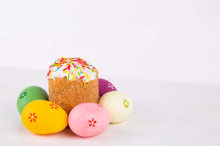 Easter cake with colorful eggs on white wooden background.の写真素材