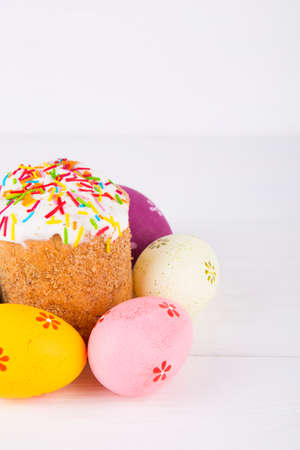 Easter cake with colorful eggs on white wooden background.の写真素材