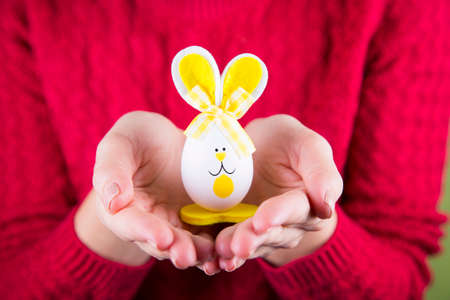 Female hands holding funny toy Easter rabbit.の写真素材