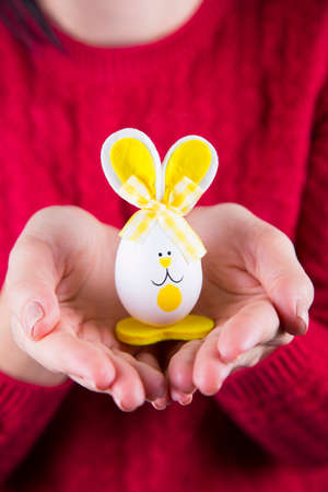 Female hands holding funny toy Easter rabbit.の写真素材