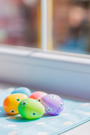 Colorful easter eggs on blue fabric near window.の写真素材