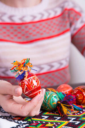 Colored easter eggs with traditional designs in female hands.の写真素材