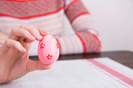 Pink colored easter egg in female hands.の写真素材