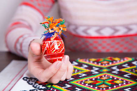 Colored easter egg with traditional designs in female hands.の写真素材