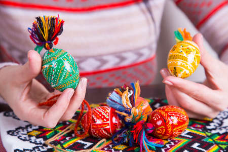 Colored easter eggs with traditional designs in female hands.の写真素材