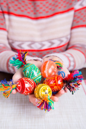 Colored easter eggs with traditional designs in female hands.