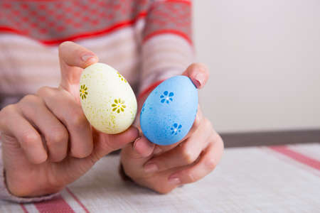Two colored easter eggs in female hands.の写真素材