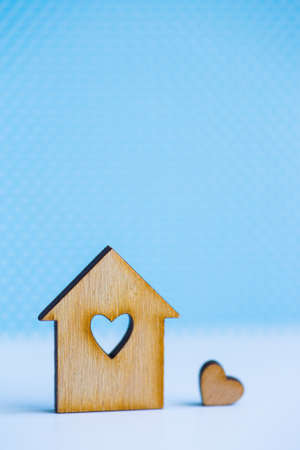 Wooden house with hole in form of heart with little heart on blue background.の写真素材
