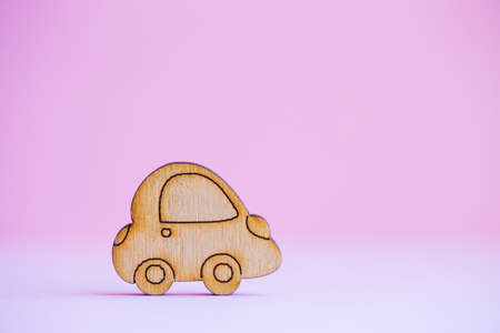 Wooden car icon on light pink background. Concept of moving. Symbol of traveling.の写真素材