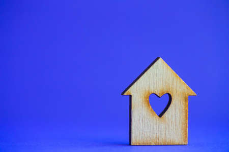 Wooden house with hole in form of heart on blue background.の写真素材