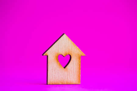 Wooden house with hole in form of heart on crimson background.の写真素材