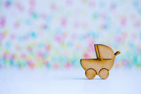 Wooden icon of baby buggy on colorful background. Sign of baby carriage. Concept of childbirth.の写真素材