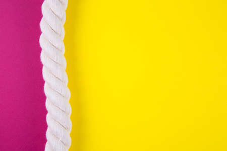 Sea rope on colored yellow and crimson backgrounds with negative space. Minimalistic colorful summer background. Top view. Flat lay in marine style.の写真素材