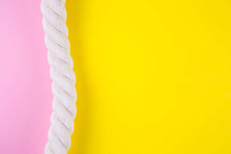 Sea rope on colored yellow and pink backgrounds with negative space. Minimalistic colorful summer background. Top view. Flat lay in marine style.の写真素材