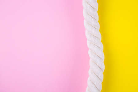 Sea rope on colored yellow and pink backgrounds with negative space. Minimalistic colorful summer background. Top view. Flat lay in marine style.の写真素材