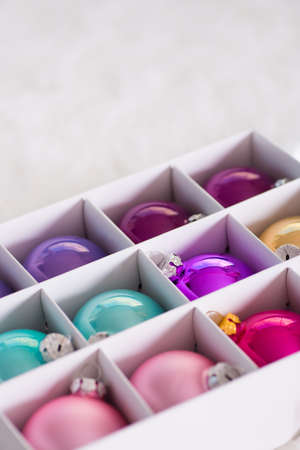 Colorful Christmas balls in white box. New Year holiday shopping. Package with xmas decoration.の写真素材