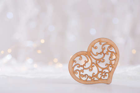 Wooden ornate heart with garland lights on background. Romantic card.の写真素材