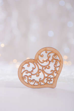 Wooden ornate heart with garland lights on background. Romantic card.の写真素材