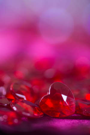 Many red little crystal hearts with bokeh background. Romantic card on St. Valentine's Day.の写真素材