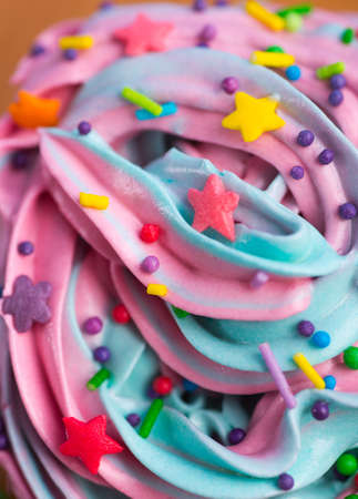Closeup cupcake creamy multicolored top with colorful stars and sprinkles. Birthday party or Christmas cake. の写真素材
