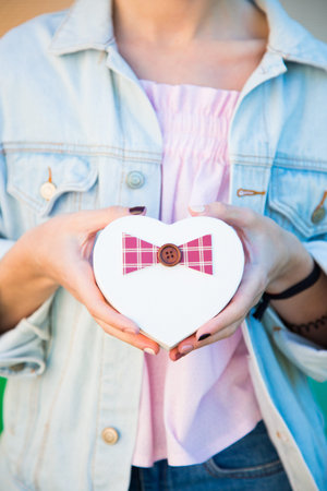 Female hands holding gift box in shape of heart in her hands. Romantic banner for Valentineâ€™s...