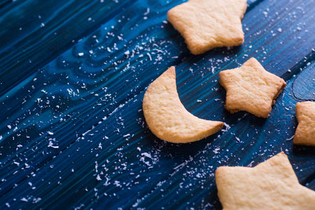 Closeup homemade Christmas cookies in form of stars and Moon on table. New Year baked biscuit.