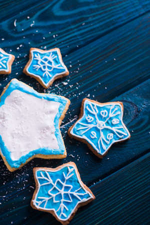 Closeup homemade Christmas glazed cookies decorated with snowflakes on table. New Year biscuit in form of stars.の写真素材