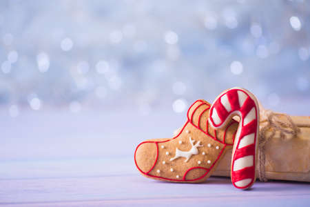 Glazed festive Christmas gingerbread in form of boot and caramel cane on light bokeh background. Holiday bakery. New Year sweet cookie.の写真素材