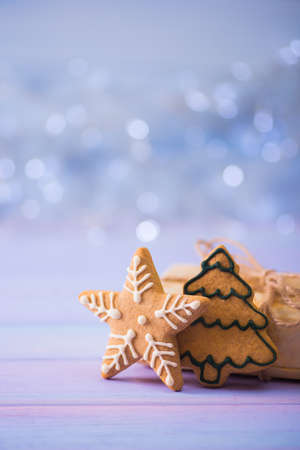 Glazed festive Christmas gingerbread in form of star and fir on light bokeh background. Holiday bakery. New Year sweet cookie.の写真素材