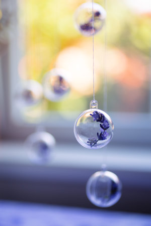 Lavender flowers hanging in transparent balls near sunny window indoor in summer. Natural decor....