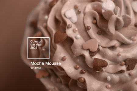 Closeup cupcake creamy multicolored top with hearts and sprinkles toned in brown colors. Romantic cake for Valentineâs day. Chocolate or mocha coffee mousse.の写真素材