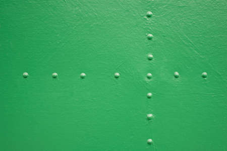 Old painted metal with rivets painted in greenの写真素材