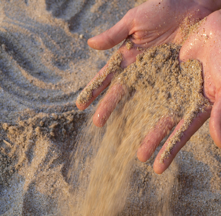 sand falling from handsの写真素材