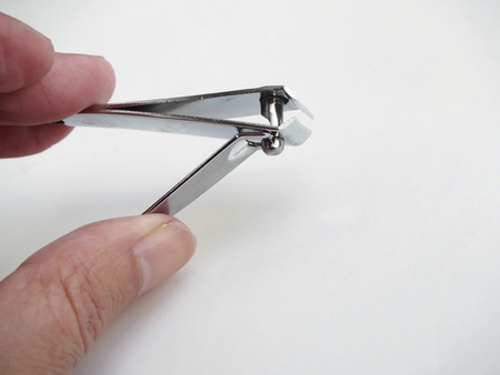 Nail clipper with hand on white backgroundの写真素材