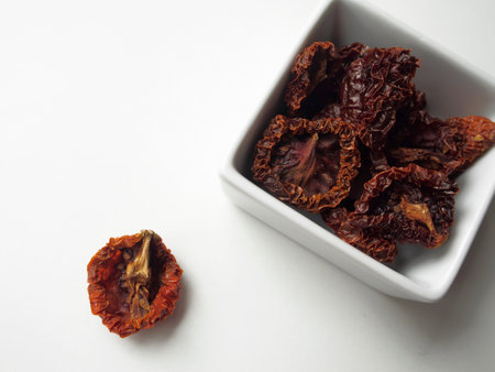 Dried tomatoes in bowl on white backgroundの写真素材
