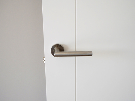Metal handle in white doorの写真素材