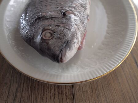 Sargo in a plate on wood backgroundの写真素材