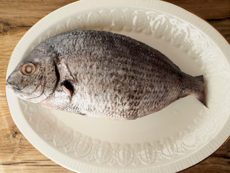 Sargo in a plate on wood background