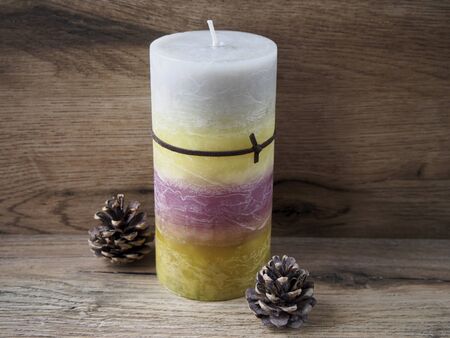 Colorful candle with two pine conesの写真素材