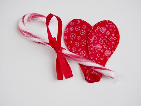 Two deflated red balloon forming a heart with cane candyの写真素材