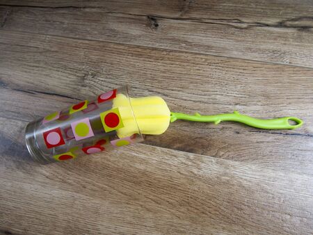 Flower-shaped sponge to wash the glasses on wood backgroundの写真素材