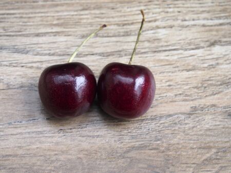 Two cherries on wood backgroundの写真素材